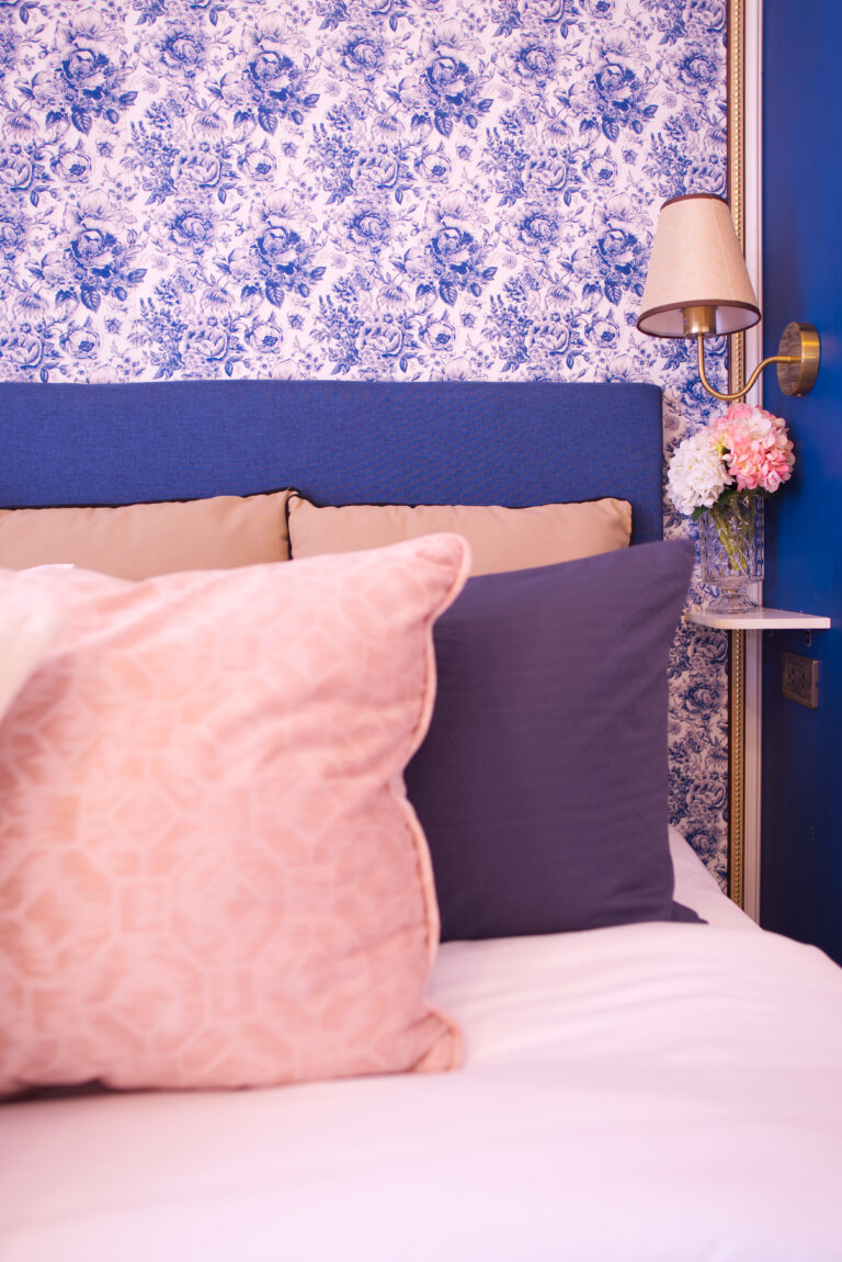 Detail of bed in chambre secrete with pillows and side table / lighting