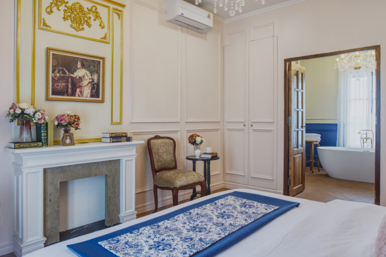 Chambre Soleil with view of fireplace, sitting area, hidden storage on each side of the bathroom entrance and view of bathroom