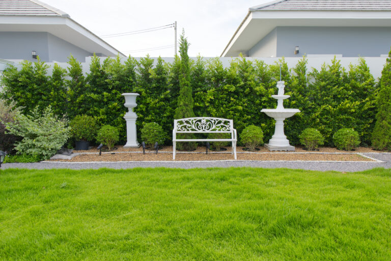 View of garden and sitting area on the side of the garden next to walkway and decorative elements in background