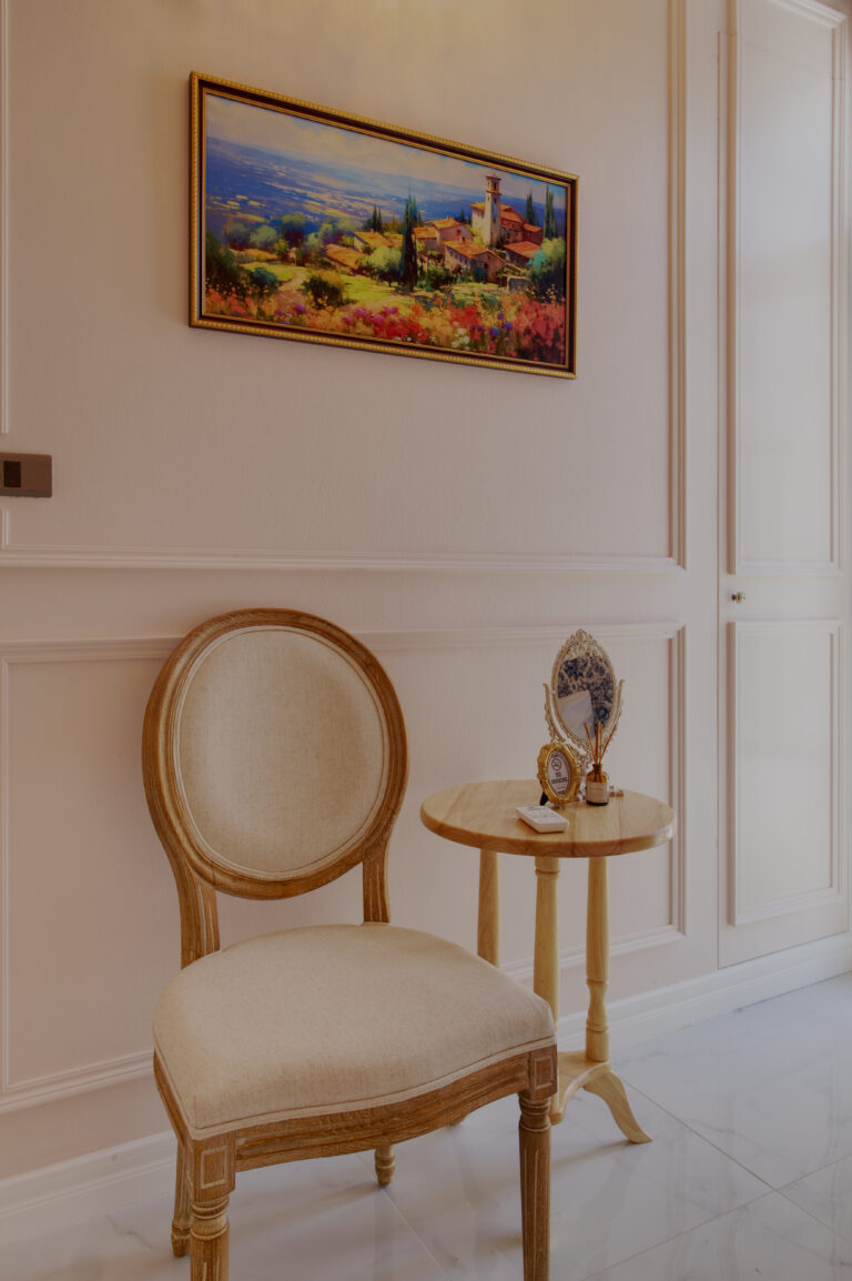 Detail of chair, small table and decorative painting in "chambre surprise"