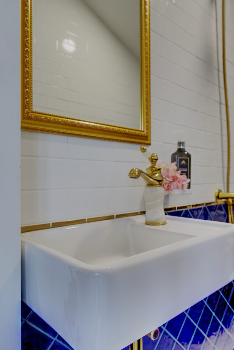 Sink and mirror detail in bathroom located under stairs