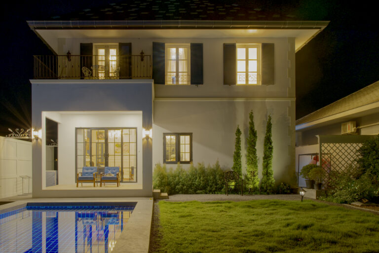 Overview of the house from garden / swimming pool side at night