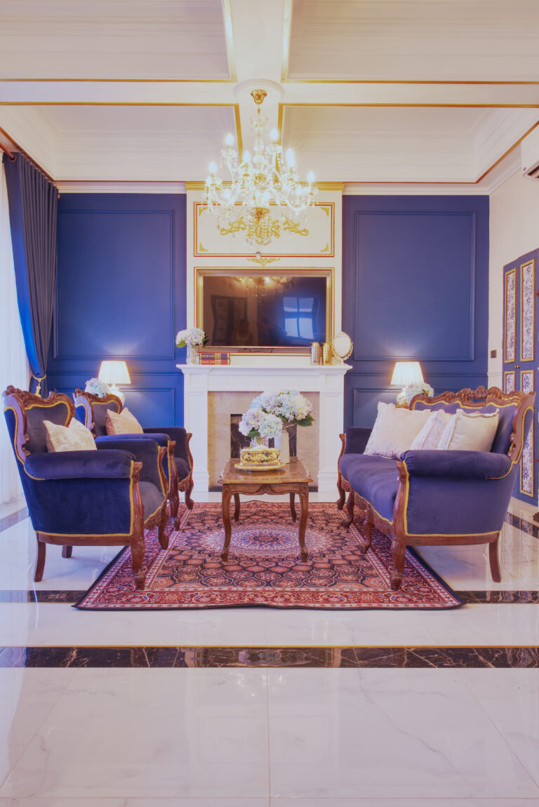View from the dining area towards living room with sofa and armchairs, TV and decorative fireplace